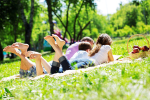 kids laying on a blanket in a park